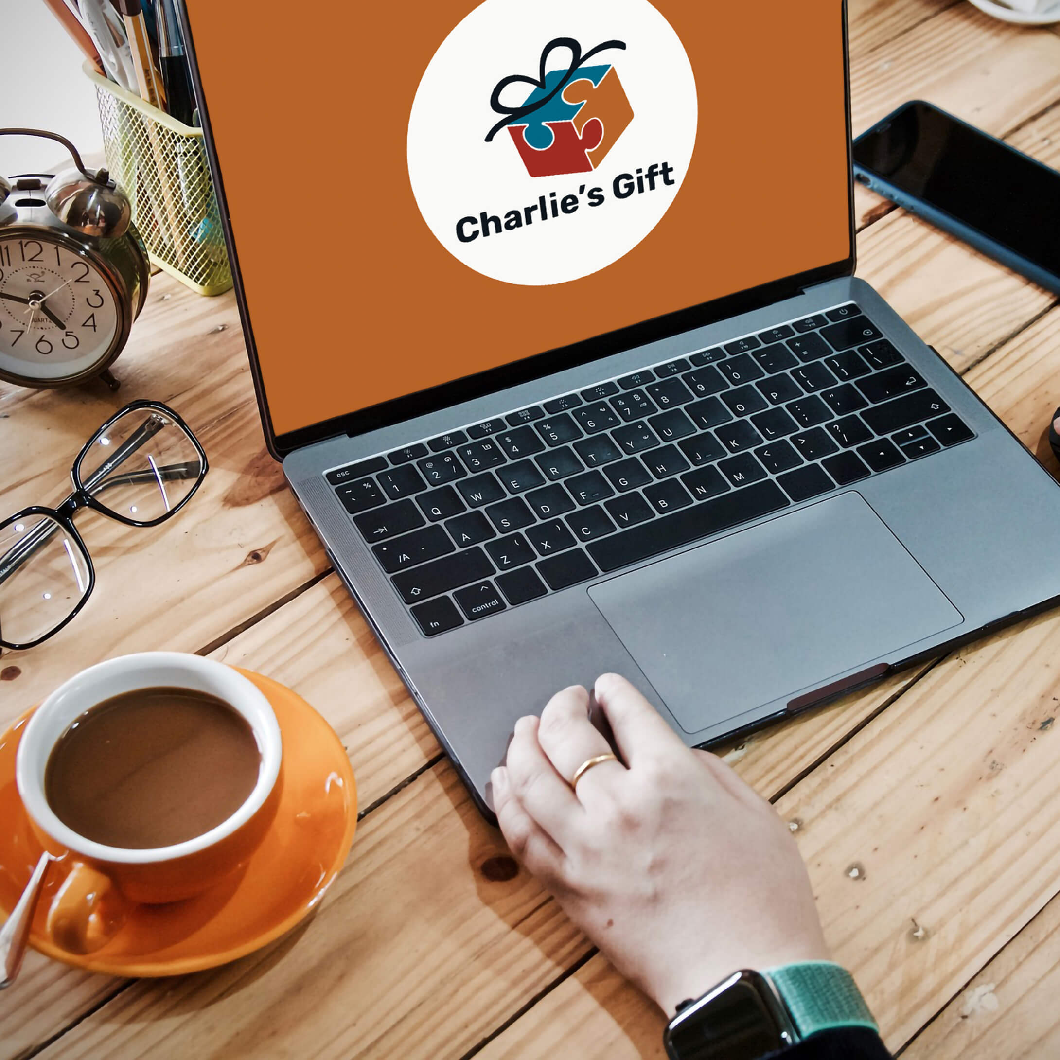 contact-banner-image person using a laptop computer with charlie's gift logo on the screen