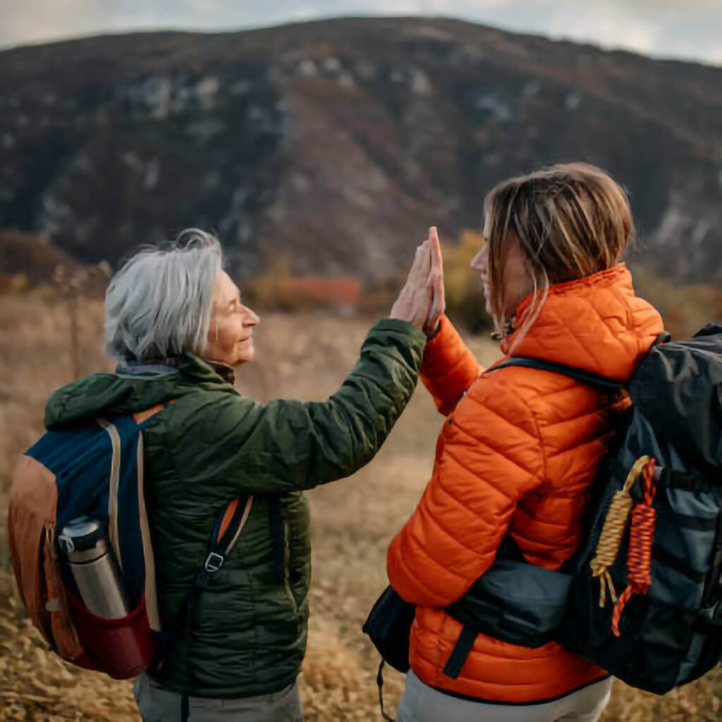 Older woman hiking in the mountains with a younger woman